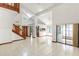 Open-concept living area featuring tile floors, a wooden staircase, and large windows providing ample natural light at 271 Morning Glory Dr, Lake Mary, FL 32746