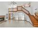 Spacious living room featuring a brick fireplace, tile flooring, staircase, and soaring ceilings at 271 Morning Glory Dr, Lake Mary, FL 32746