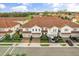 An aerial view of a townhouse community with red tile roofs and lush green landscaping at 2710 Bolzano Dr, Apopka, FL 32712