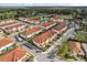 Aerial view of Sweetwater community featuring white homes, terracotta roofs, a pond, and lush greenery at 2710 Bolzano Dr, Apopka, FL 32712