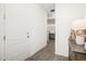 Hallway featuring wood-look floors, white door, and view into the living room at 2710 Bolzano Dr, Apopka, FL 32712
