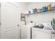 Functional laundry room with a washer, dryer, storage shelves, and space-saving design at 2710 Bolzano Dr, Apopka, FL 32712
