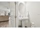 Cozy powder room with a pedestal sink, oval mirror, and modern fixtures at 2710 Bolzano Dr, Apopka, FL 32712