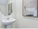Stylish bathroom with a pedestal sink, modern mirror, and contemporary artwork creating an elegant space at 2903 Canary Ave, Davenport, FL 33837