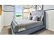 Cozy bedroom with a plush gray bed, decorative pillows, and a window with scenic views at 2903 Canary Ave, Davenport, FL 33837