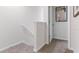 Bright upstairs hallway with carpet and a door leading to another room and a decorative art piece at 2903 Canary Ave, Davenport, FL 33837