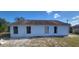 Exterior backyard view features a white home with three windows and a door at 3166 Canby Dr, Deltona, FL 32738