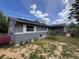 View of the house's exterior with brick foundation, well-maintained lawn, and solar panels at 3219 Chariot Pl, Orlando, FL 32818