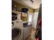 Functional laundry room with modern washer and dryer, overhead storage, and a door to the exterior at 3219 Chariot Pl, Orlando, FL 32818