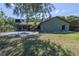 Expansive backyard featuring a patio, green grass, and mature trees, perfect for outdoor activities at 3220 Cardigan Ct, Orlando, FL 32812