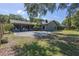 Large backyard with a patio area, basketball hoop, lush lawn, and mature trees at 3220 Cardigan Ct, Orlando, FL 32812