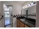 Bathroom features granite counters, vanity lighting, and a black and white checkered tile backsplash at 3220 Cardigan Ct, Orlando, FL 32812