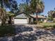 Charming single-story home with a two-car garage, mature trees, and a welcoming front entrance at 3220 Cardigan Ct, Orlando, FL 32812