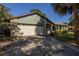 Charming home featuring stone accents, an attached garage, and tropical landscaping at 3220 Cardigan Ct, Orlando, FL 32812
