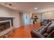 Comfortable living room with stone fireplace, wood floors, and access to the kitchen at 3220 Cardigan Ct, Orlando, FL 32812
