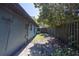 Side yard with partial fence, grassy area, and trees providing shade and privacy at 3220 Cardigan Ct, Orlando, FL 32812