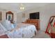 Cozy bedroom showcasing a comfortable bed and classic wooden furniture, with a large TV at 325 N Causeway # D-206, New Smyrna Beach, FL 32169