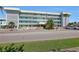 Exterior of a light teal condominium building with 'Waterway East' signage, palm trees, and ample parking at 325 N Causeway # D-206, New Smyrna Beach, FL 32169