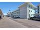 Side exterior of the light teal condominium building with carport and parking spaces at 325 N Causeway # D-206, New Smyrna Beach, FL 32169