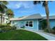 Charming single-story home featuring a light blue exterior with a silver metal roof and well-maintained landscaping at 325 N Causeway # D-206, New Smyrna Beach, FL 32169
