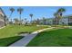 Well-manicured lawn and walkways surrounded by lush greenery and tropical palm trees at 325 N Causeway # D-206, New Smyrna Beach, FL 32169
