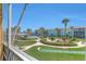 Scenic views from screened lanai of the shuffle board, pool, manicured landscaping, and building at 325 N Causeway # D-206, New Smyrna Beach, FL 32169