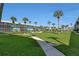 Beautifully maintained lawn with walkways, lush landscaping, and tropical palm trees against the sky at 325 N Causeway # D-206, New Smyrna Beach, FL 32169