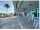 Spacious covered patio overlooking the water, furnished with rocking chairs and perfect for relaxing outdoors at 325 N Causeway # D-206, New Smyrna Beach, FL 32169