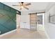 Bright bedroom featuring an accent wall, ceiling fan, and a barn door to the bathroom at 3425 N Westmoreland Dr, Orlando, FL 32804