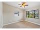 Cozy bedroom with neutral carpet, two windows, and a modern ceiling fan at 3425 N Westmoreland Dr, Orlando, FL 32804