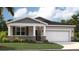 Charming single-story home featuring stone accents, a two-car garage, and well-manicured landscaping at 391 Shoreview Sands Ave, Mascotte, FL 34753