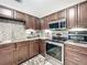This kitchen is equipped with stainless steel appliances, granite countertops, and a beautiful mosaic backsplash at 419 Newton Pl, Longwood, FL 32779