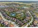 Beautiful aerial view of a community, showcasing the pool, tennis court, landscaping, and nearby lake at 4200 Oaktree Dr, Davenport, FL 33837