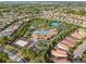 Aerial view of a community pool, tennis court, and homes in a lush green setting at 4200 Oaktree Dr, Davenport, FL 33837