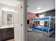Bathroom and connecting bedroom with brick accent wall, white bunk and Spiderman themed bedding at 4200 Oaktree Dr, Davenport, FL 33837