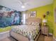 Bright bedroom with playful dinosaur mural, tan walls and trim and decorative dinosaur themed wall decor at 4200 Oaktree Dr, Davenport, FL 33837