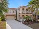 Inviting two-story home with a red tile roof, a two-car garage, and lush tropical landscaping at 4200 Oaktree Dr, Davenport, FL 33837