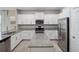 Bright kitchen features white cabinets, granite countertops, stainless appliances, an island, and tile flooring at 4200 Oaktree Dr, Davenport, FL 33837