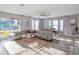 A spacious living room with a large sectional sofa, stylish decor, tile flooring, and sliding doors to the outdoor patio at 4200 Oaktree Dr, Davenport, FL 33837