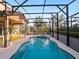 A stunning private pool with a 'Jurassic Park' sign, surrounded by lush greenery and modern outdoor furniture at 4200 Oaktree Dr, Davenport, FL 33837