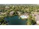 Aerial view of a serene pond, community pool, clubhouse, and green landscape at 4708 Walden Cir # 37, Orlando, FL 32811