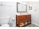Well-lit bathroom featuring a wooden vanity with ample storage and a decorative mirror at 4708 Walden Cir # 37, Orlando, FL 32811