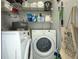 Well-organized laundry room with white washer and dryer, shelving, and storage baskets at 4708 Walden Cir # 37, Orlando, FL 32811