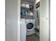Compact laundry room featuring a washer, dryer, shelving, and modern gray flooring at 4708 Walden Cir # 37, Orlando, FL 32811