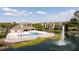 Community pool featuring a fountain, a pool house, and well-maintained landscaping overlooking a serene lake at 4708 Walden Cir # 37, Orlando, FL 32811