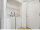 A laundry room with stackable washer and dryer tucked behind louvered doors at 4713 S Texas Ave # 4713D, Orlando, FL 32839