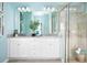 Bathroom with double vanity, white cabinets, large mirror, and walk-in shower, providing plenty of space at 503 Silver Palm Dr, Haines City, FL 33844