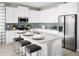 Stylish kitchen featuring a center island with seating, stainless steel appliances, and ample counter space, perfect for cooking at 503 Silver Palm Dr, Haines City, FL 33844