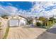 Tan exterior showcasing a well-kept home with an attached garage and manicured landscaping at 509 Eastwood Ln, Daytona Beach, FL 32118
