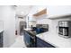 Galley kitchen features white cabinets, dark countertops and stainless steel appliances at 509 Eastwood Ln, Daytona Beach, FL 32118